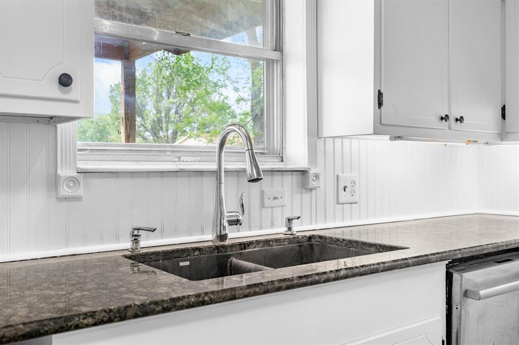 417 West 8th Street Justin, TX 76247 - Photo 14 of 40 a kitchen with granite countertop a sink and a window