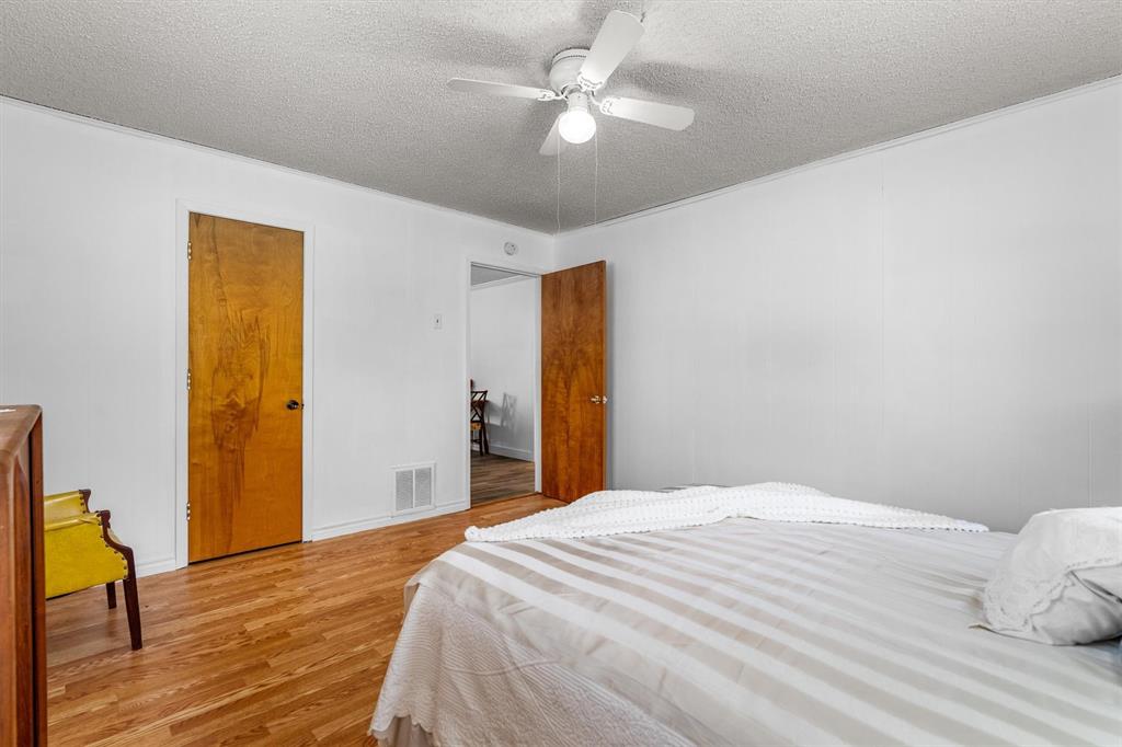 417 West 8th Street Justin, TX 76247 - Photo 16 of 40 a bedroom with a bed and wooden floor
