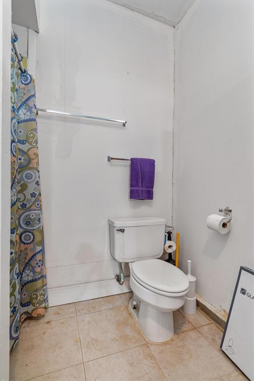 417 West 8th Street Justin, TX 76247 - Photo 22 of 40 a white toilet sitting next to a shower curtain