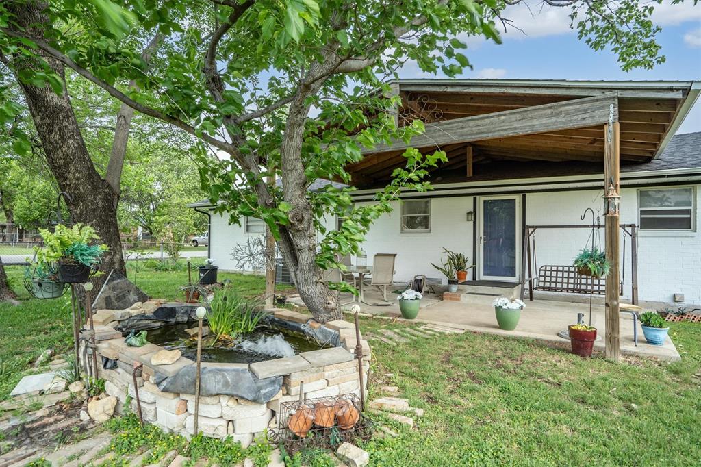417 West 8th Street Justin, TX 76247 - Photo 25 of 40 a view of a chair and table in backyard of the house