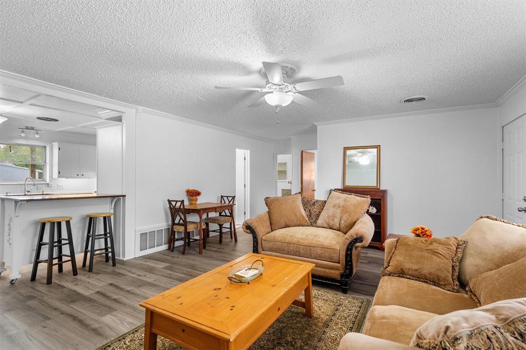 417 West 8th Street Justin, TX 76247 - Photo 9 of 40 a living room with furniture a dining table and a fireplace