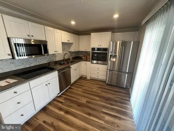 a kitchen with granite countertop a refrigerator stove and sink