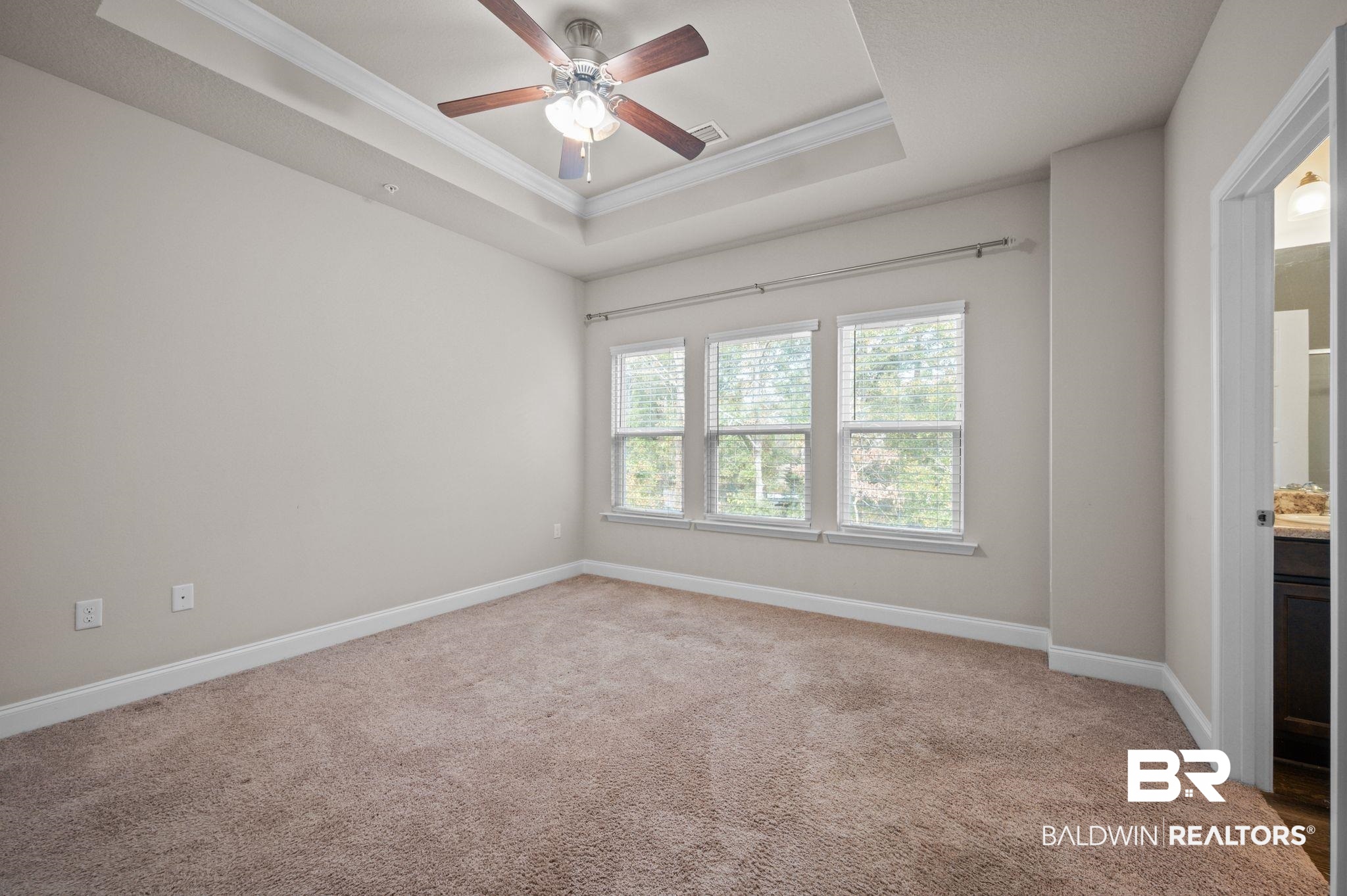 6903 Spaniel Drive, Unit B Spanish Fort, AL 36527 - Photo 13 of 28 Carpeted spare room with ceiling fan, visible vents, baseboards, a tray ceiling, and crown molding