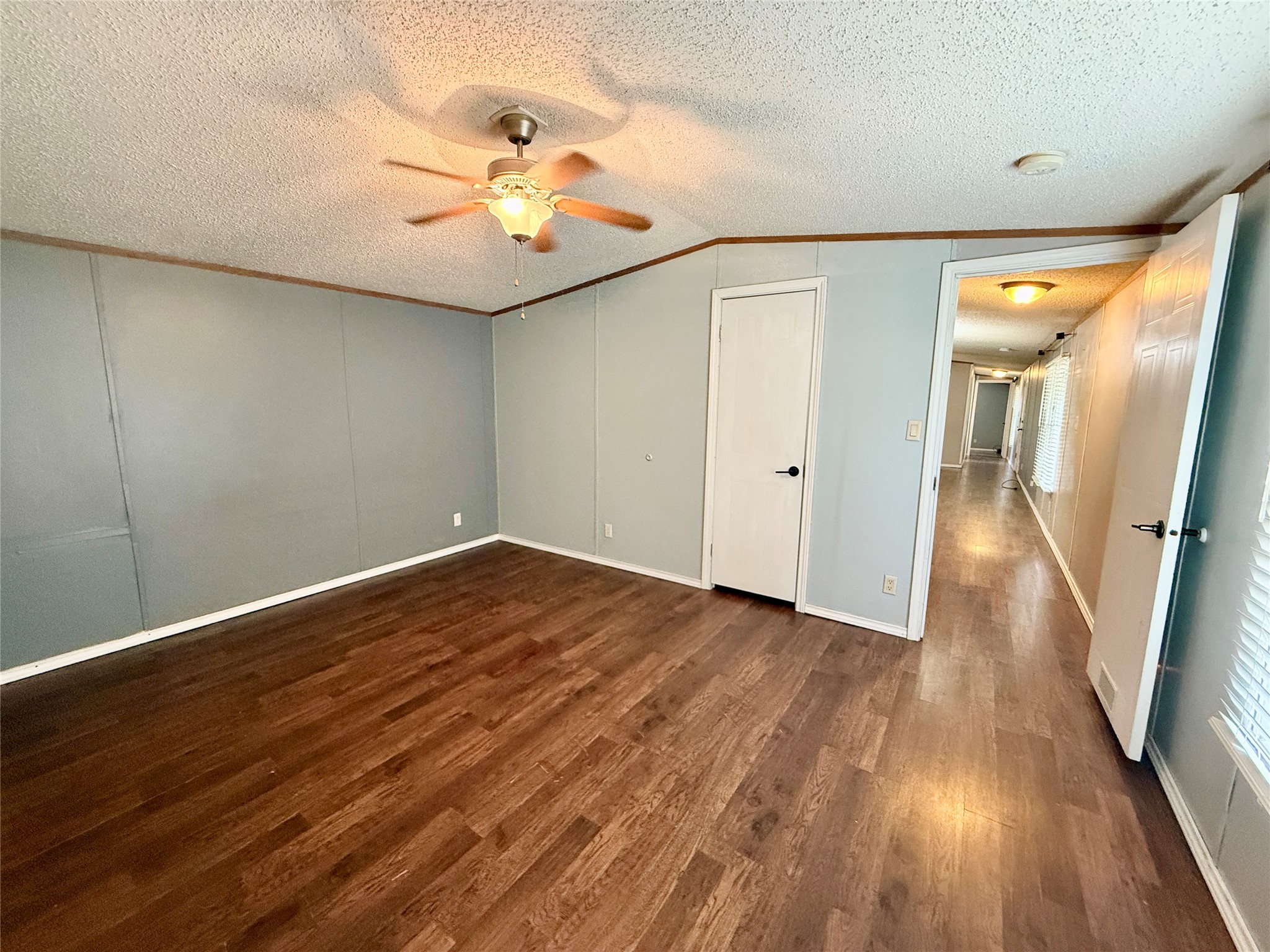 3075 FM 2001 Buda, TX 78610 - Photo 11 of 26 Wood flooring and panel walls define this inviting living space, complete with ceiling light.