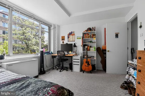 a bedroom with bed and a large window