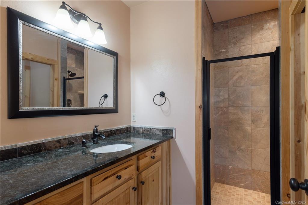 211 Lagrange Road, Unit TRACK 2 Waynesville, NC 28786 - Photo 30 of 48 a bathroom with a granite countertop sink and a mirror
