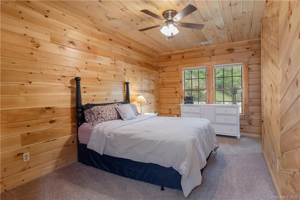 211 Lagrange Road, Unit TRACK 2 Waynesville, NC 28786 - Photo 31 of 48 a spacious bedroom with a bed and a chandelier