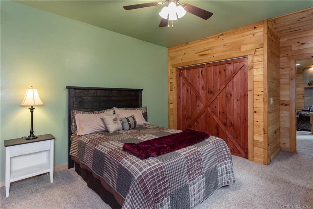 211 Lagrange Road, Unit TRACK 2 Waynesville, NC 28786 - Photo 34 of 48 a bedroom with a bed and a chandelier
