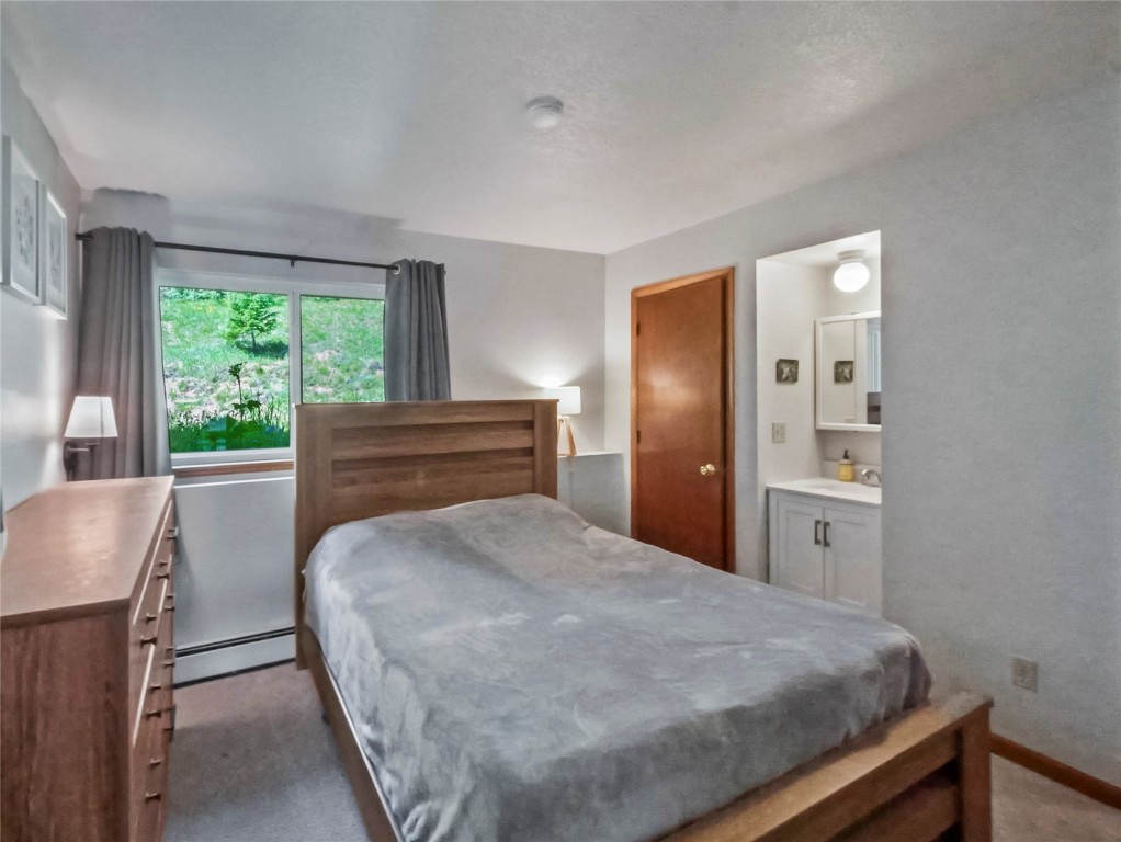 9876 Ryan Gulch Road, Unit 106 Silverthorne, CO 80498 - Photo 12 of 27 a bedroom with a bed and a large window