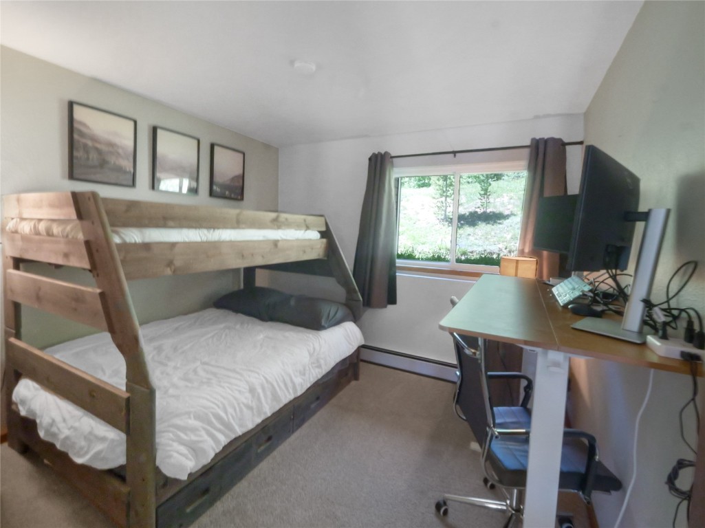 9876 Ryan Gulch Road, Unit 106 Silverthorne, CO 80498 - Photo 17 of 27 a bedroom with a bed and a flat screen tv