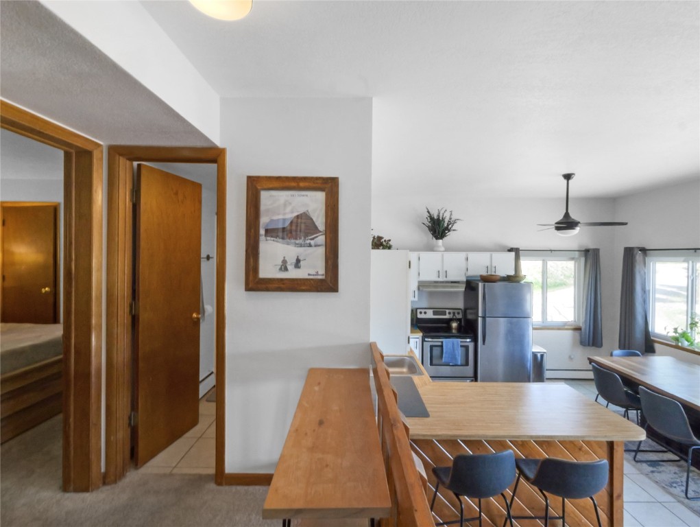 9876 Ryan Gulch Road, Unit 106 Silverthorne, CO 80498 - Photo 18 of 27 a dining room with wooden floor and kitchen view