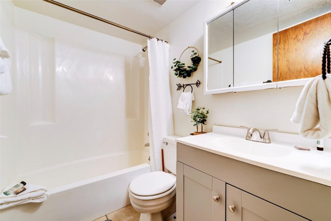 9876 Ryan Gulch Road, Unit 106 Silverthorne, CO 80498 - Photo 19 of 27 a bathroom with a sink toilet and shower