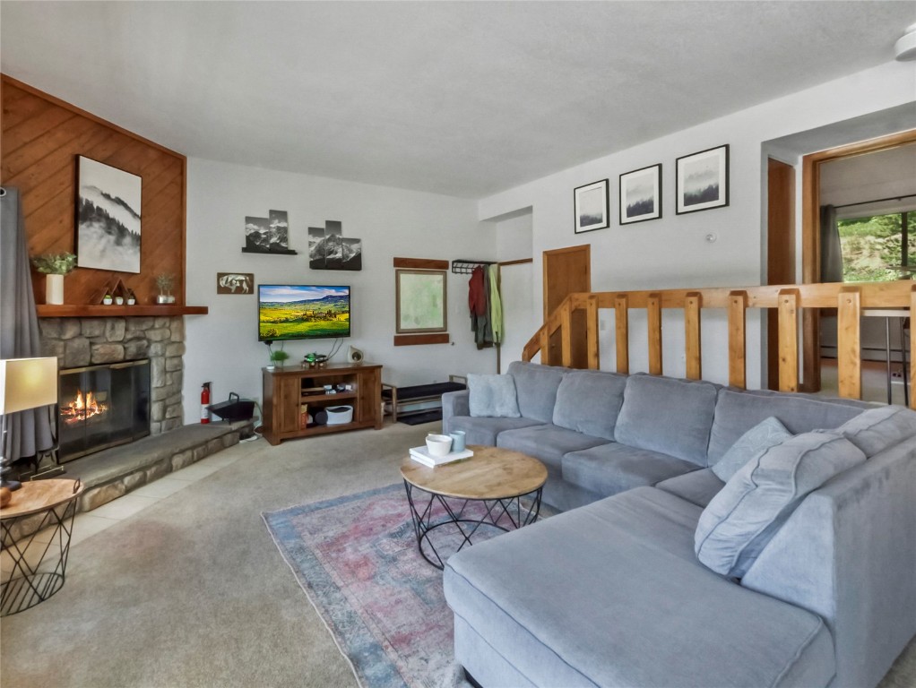 9876 Ryan Gulch Road, Unit 106 Silverthorne, CO 80498 - Photo 2 of 27 a living room with furniture and a fireplace