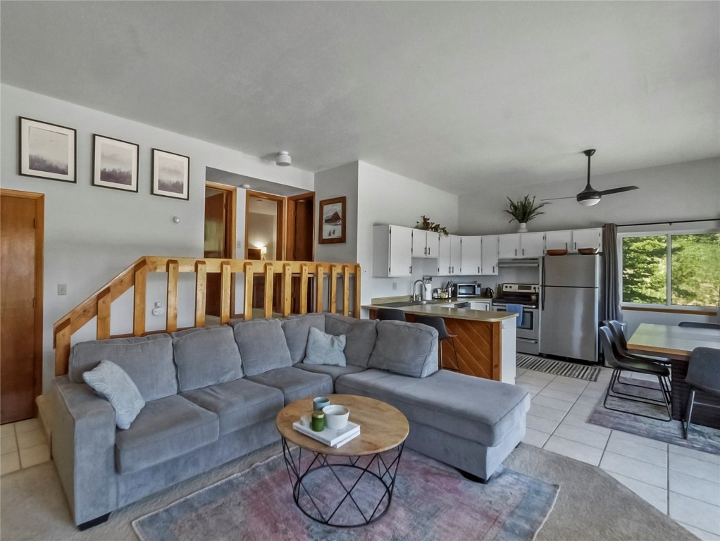 9876 Ryan Gulch Road, Unit 106 Silverthorne, CO 80498 - Photo 3 of 27 a living room with furniture a rug and kitchen view