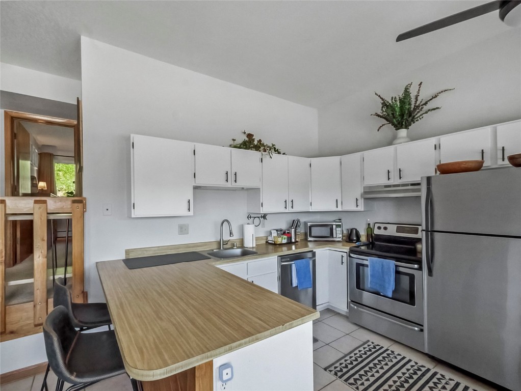 9876 Ryan Gulch Road, Unit 106 Silverthorne, CO 80498 - Photo 5 of 27 a kitchen with a white stove top oven and refrigerator