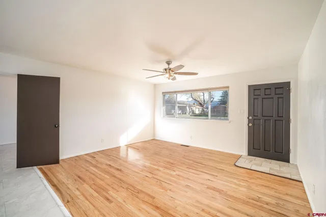 a view of a room with wooden floor and white walls