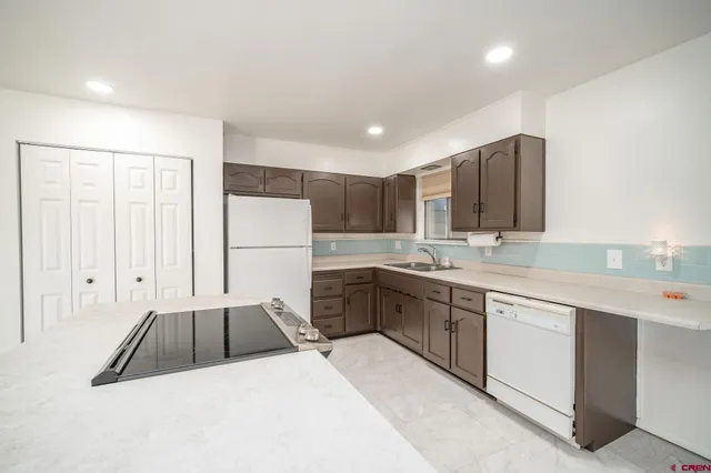 a kitchen with a sink refrigerator and cabinets
