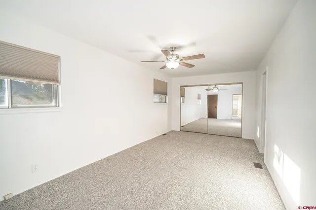 a view of a big room with closet and chandelier fan