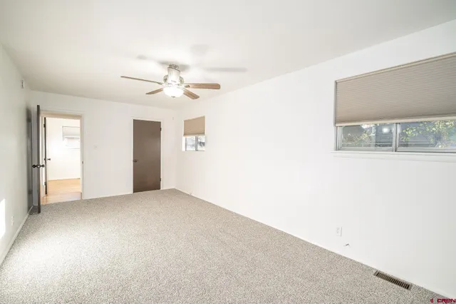 a view of a livingroom with a ceiling fan and window