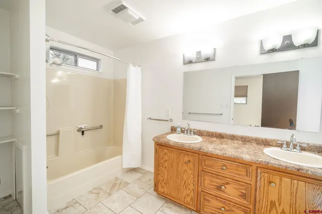 a bathroom with a granite countertop sink mirror and shower