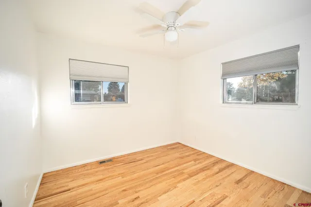 a view of empty room with wooden floor