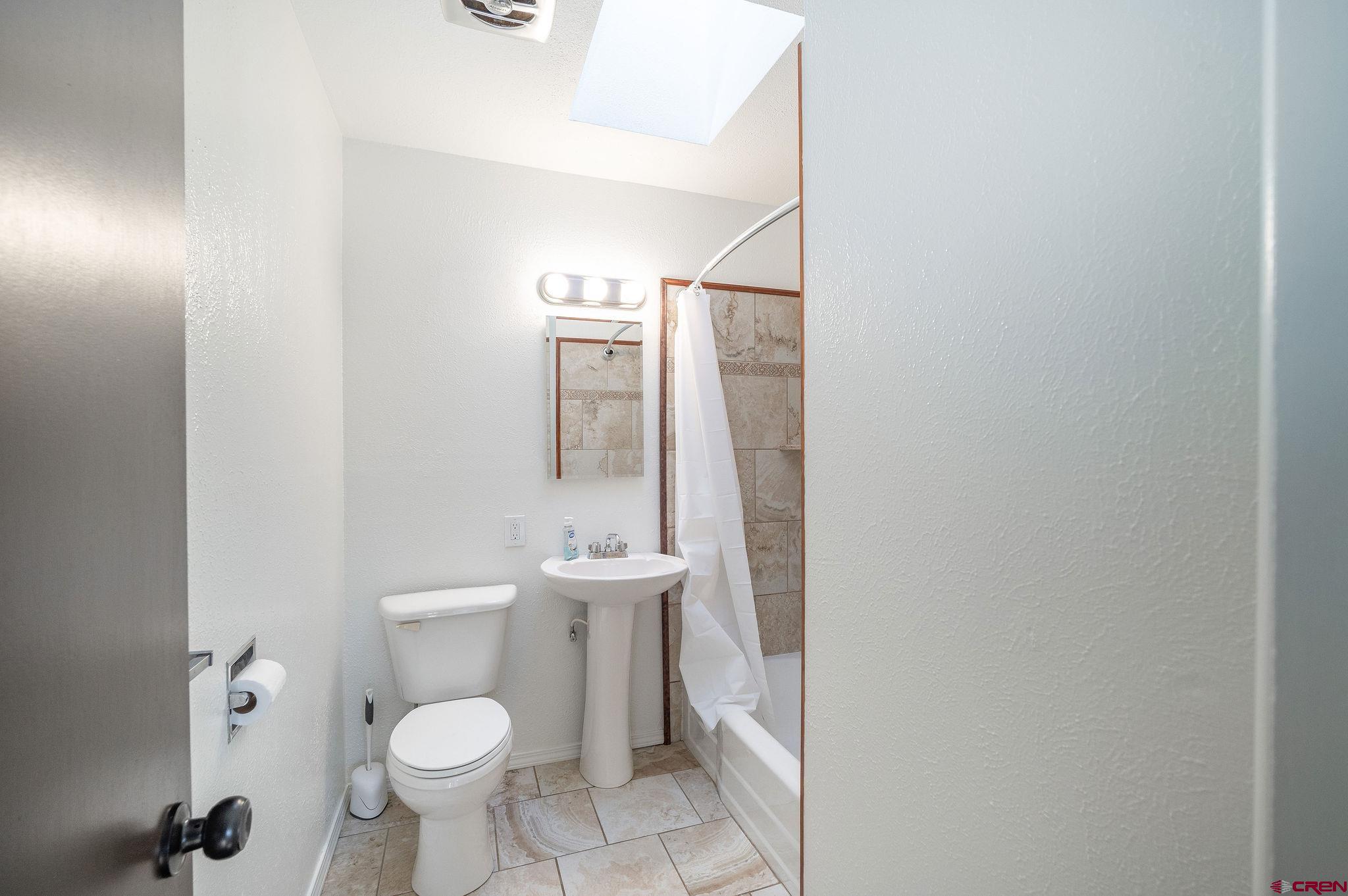 608 Alameda Drive Cortez, CO 81321 - Photo 25 of 32 a bathroom with a toilet sink and mirror