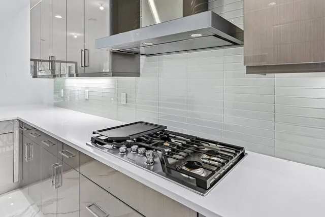 a stove top oven sitting inside of a kitchen