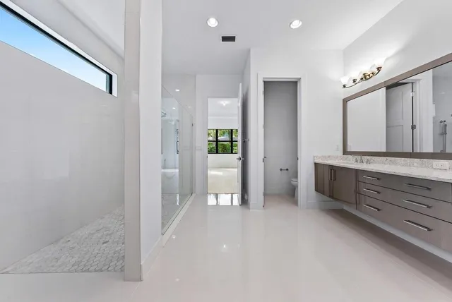 a bathroom with a glass door shower a sink and a mirror