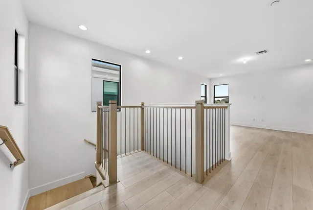 a view of a hallway with wooden floor and staircase