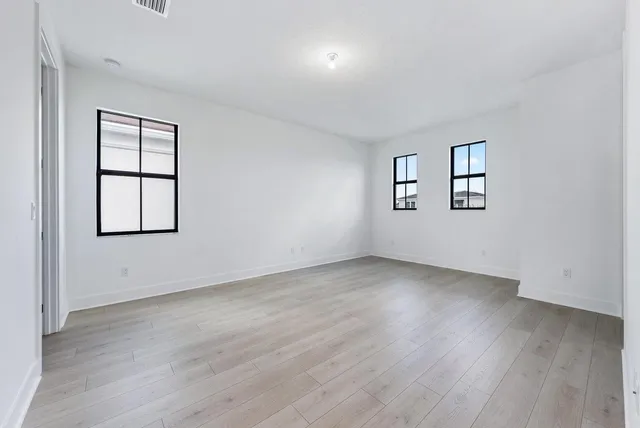 an empty room with windows and closet