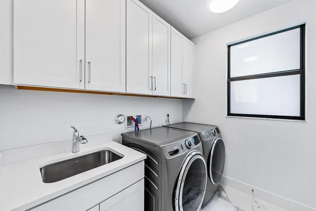 a utility room with sink dryer and washer