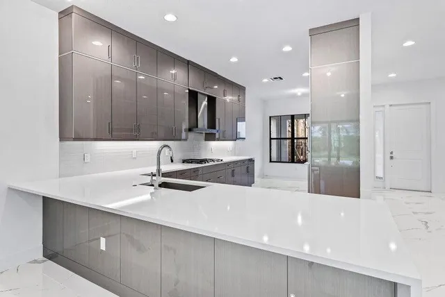 a large white kitchen with a large window