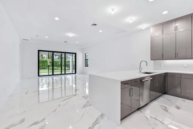a view of a kitchen with a sink and dishwasher cabinet with wooden floor