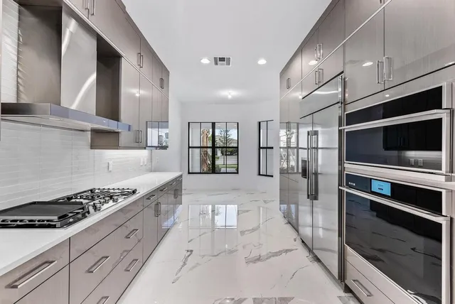 a kitchen with stainless steel appliances kitchen island granite countertop a stove and cabinets