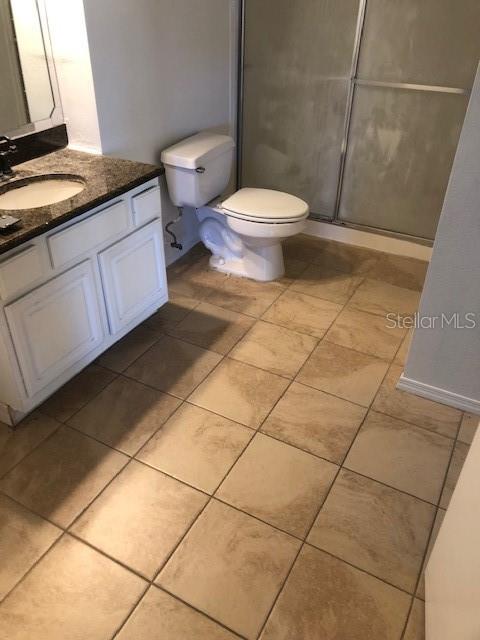 413 Summit Ridge Place, Unit 305 Longwood, FL 32779 - Photo 8 of 11 a bathroom with a granite countertop toilet and a sink