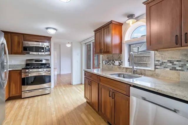 a kitchen with stainless steel appliances granite countertop a refrigerator stove top oven and sink