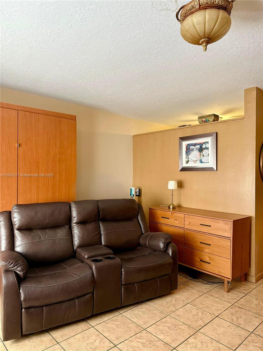 15610 Northeast 6th Avenue, Unit 32D Miami, FL 33162 - Photo 6 of 15 a living room with furniture and a mirror