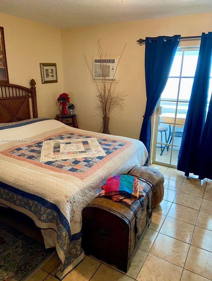 15610 Northeast 6th Avenue, Unit 32D Miami, FL 33162 - Photo 9 of 15 a bedroom with a bed and wooden floor