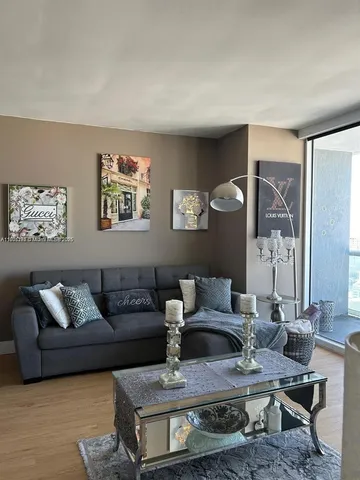 a living room with furniture wooden floor and wall paintings