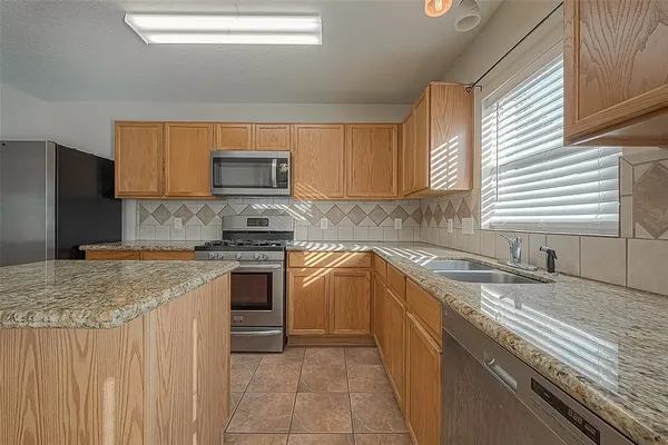 a kitchen with granite countertop a sink stove and cabinets