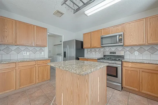 a kitchen with stainless steel appliances granite countertop a sink stove and cabinets