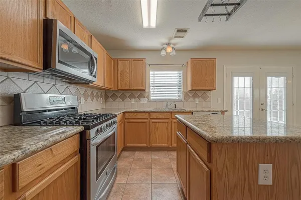 a kitchen with stainless steel appliances granite countertop a sink stove and cabinets
