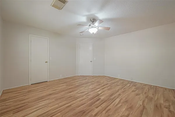 a view of empty room with wooden floor