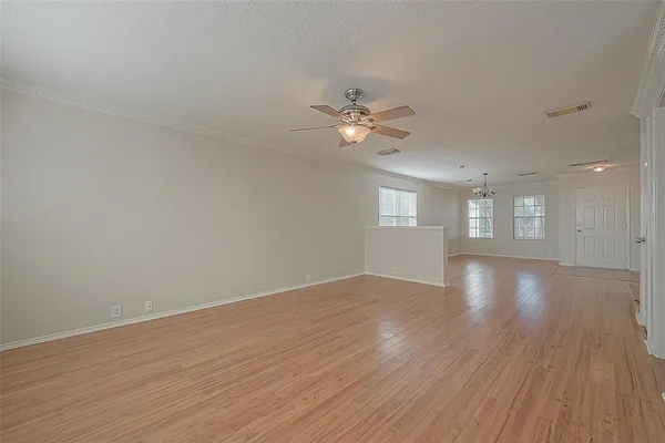 a view of an empty room with a window and wooden floor