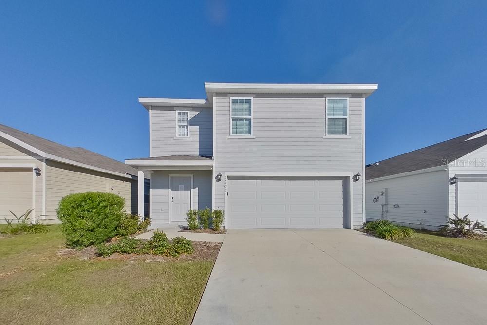 4397 Southwest 85th Lane Ocala, FL 34476 - Photo 1 of 23 a front view of a house with a yard and garage