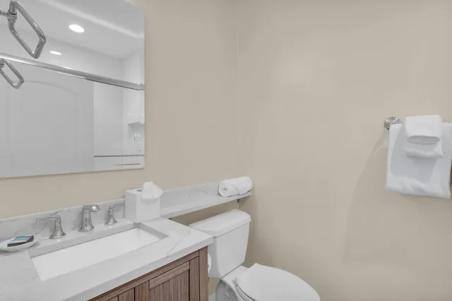 a bathroom with a sink mirror vanity and toilet