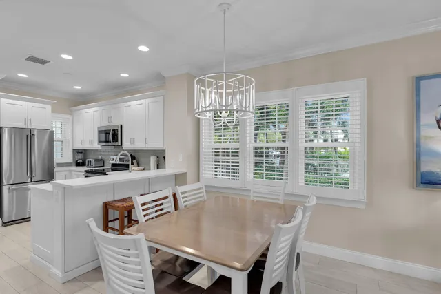 a kitchen with stainless steel appliances granite countertop a kitchen island a stove a table and a refrigerator