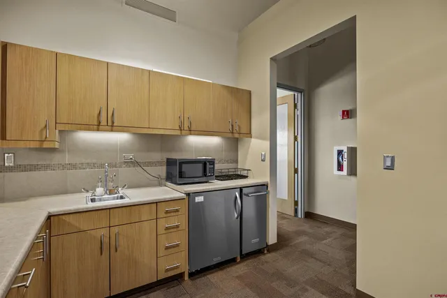 a kitchen with cabinets appliances a sink and a counter top space
