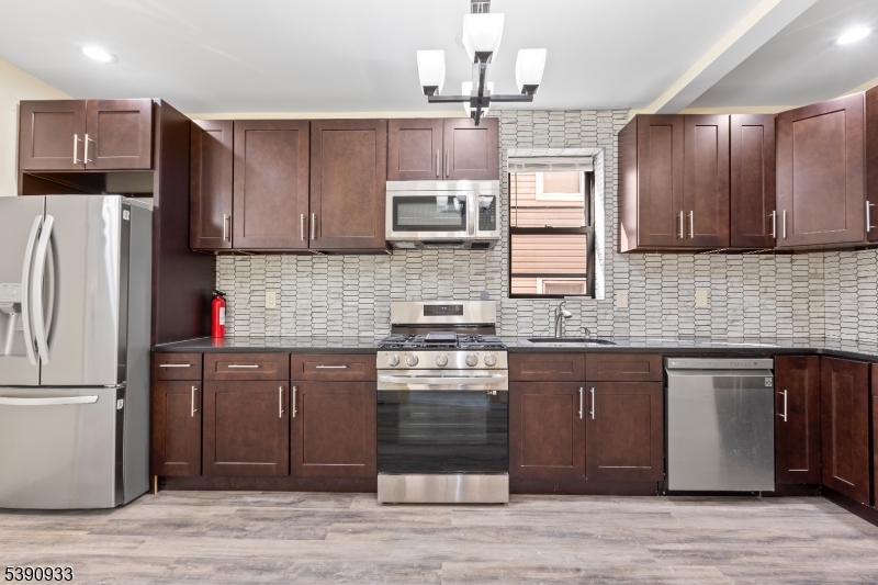 a kitchen with kitchen island granite countertop wooden cabinets and a stainless steel appliances