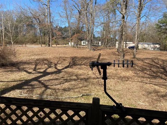 a view of a yard with wooden fence